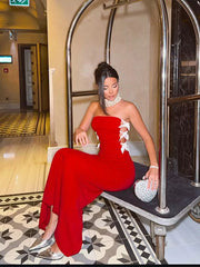 Woman in a red dress sitting on a vintage chair in an elegant interior setting.