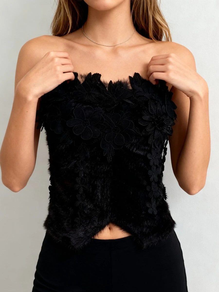 Black floral strapless top worn by a model against a plain background