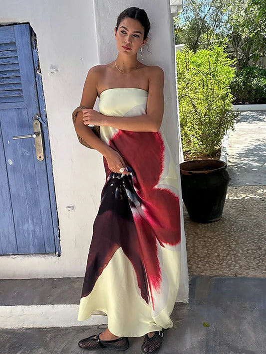 Woman wearing a strapless dress with a colorful design outdoors.