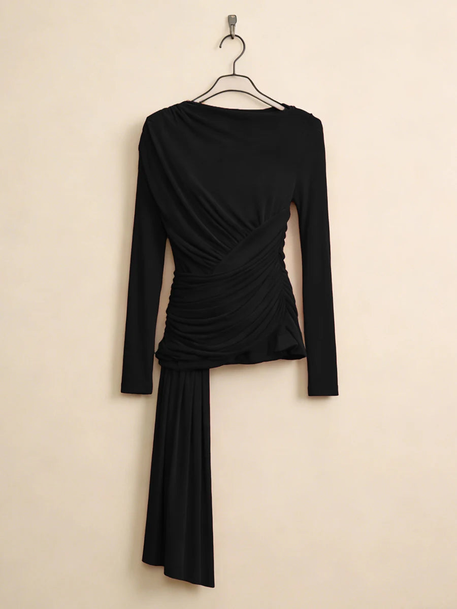 Black long-sleeve dress with a draped design on a beige background