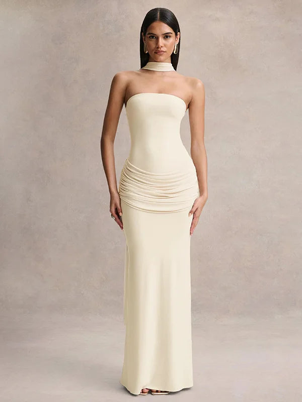 Woman wearing a strapless, floor-length cream dress against a neutral background