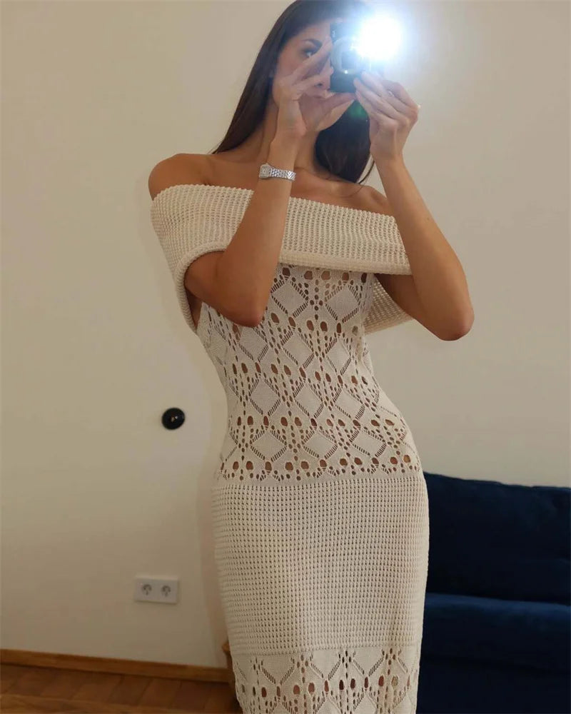 Woman wearing a white crochet off-shoulder dress taking a mirror selfie.