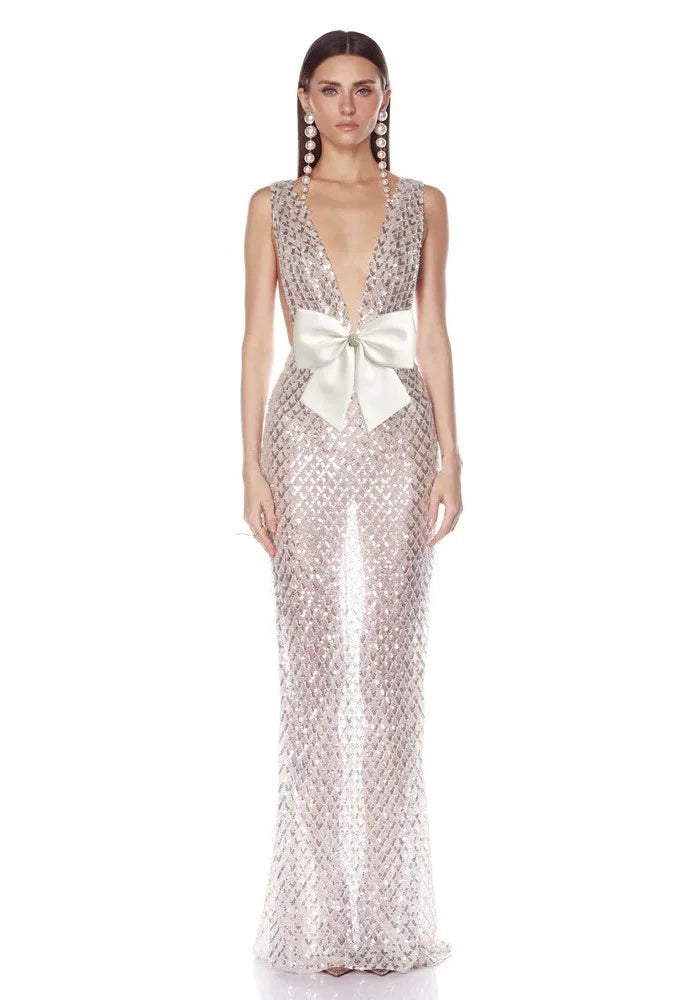 Front view of a silver sequined V-neck gown with a large white bow.