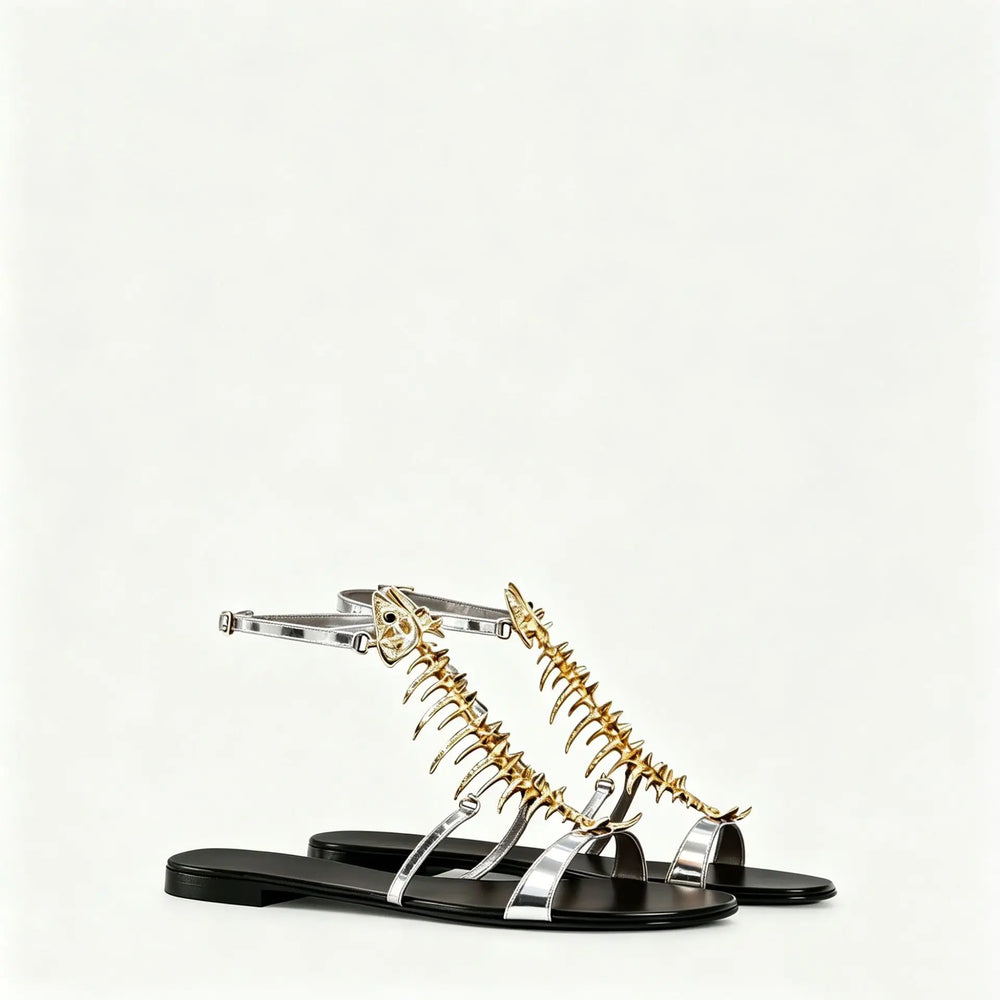 Pair of metallic silver and black flat sandals with gold fishbone embellishments