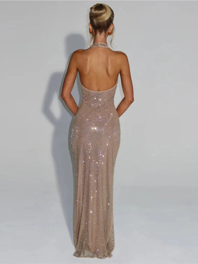 Woman wearing a sparkly, long evening gown against a plain background