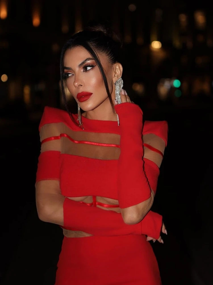 Woman wearing a red outfit with sheer panels against a dark background