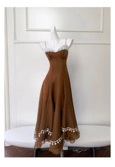 Brown lace-trimmed A-line midi dress on white table