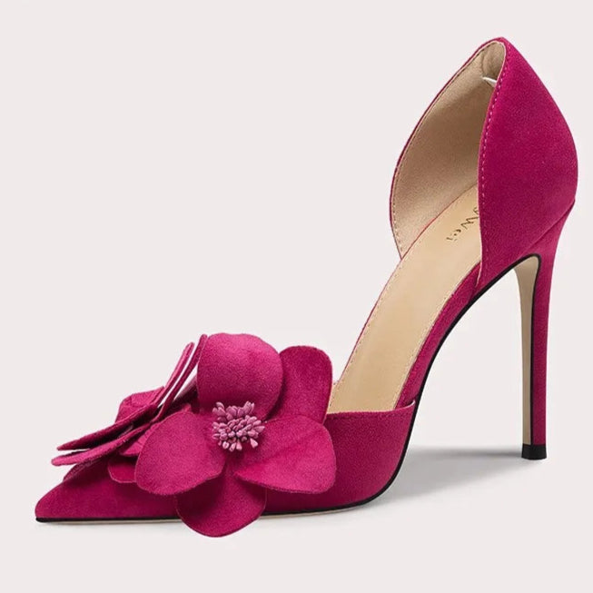 Pink high-heeled shoe with floral design on a light gray background