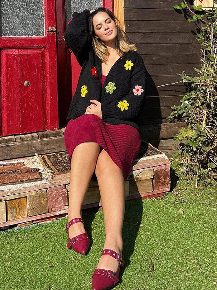Person wearing a floral appliqu� knit cropped cardigan outdoors