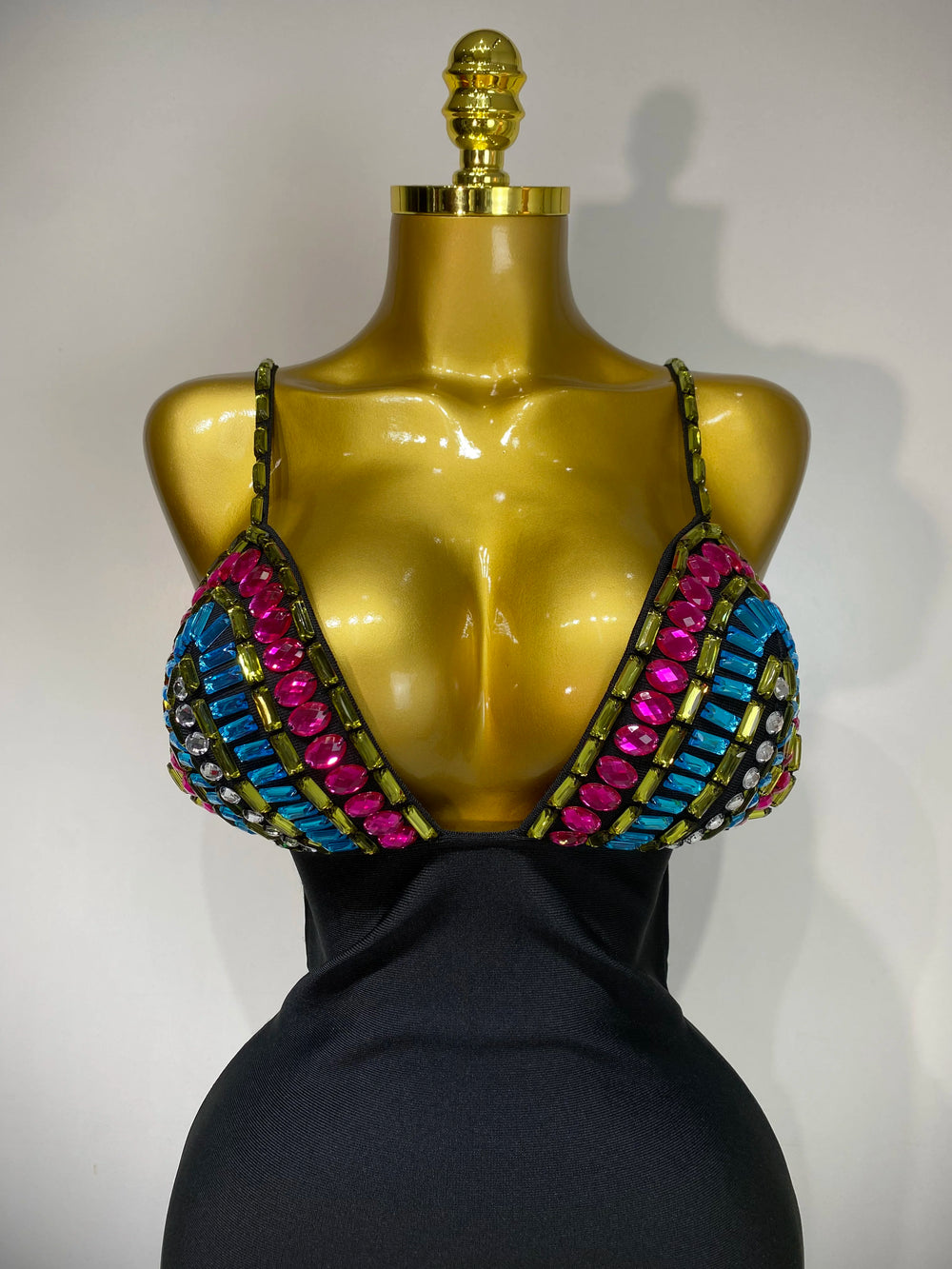 Mannequin wearing a colorful beaded top with a plain background