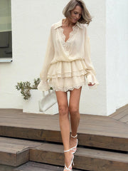 Beige mini dress with cross neck and lace trim