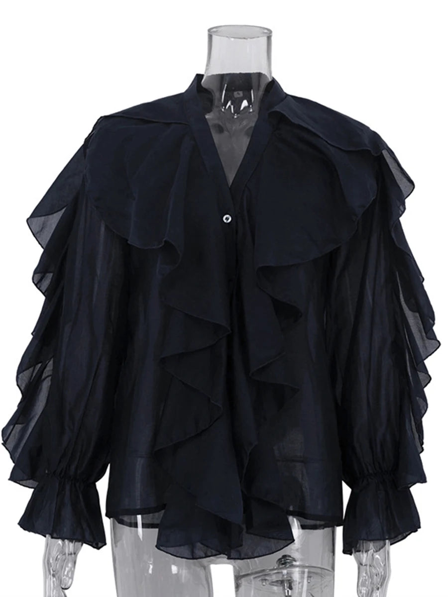 Black ruffled blouse on a mannequin against a white background