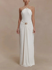 White halter neck gown with a gold belt on a beige background