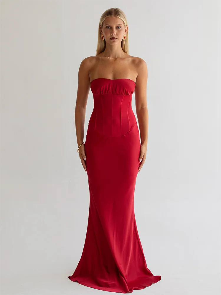 Woman wearing a strapless red evening gown on a plain background