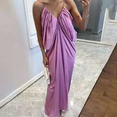 Person wearing a long purple dress in a room with a mirror and tiled floor.