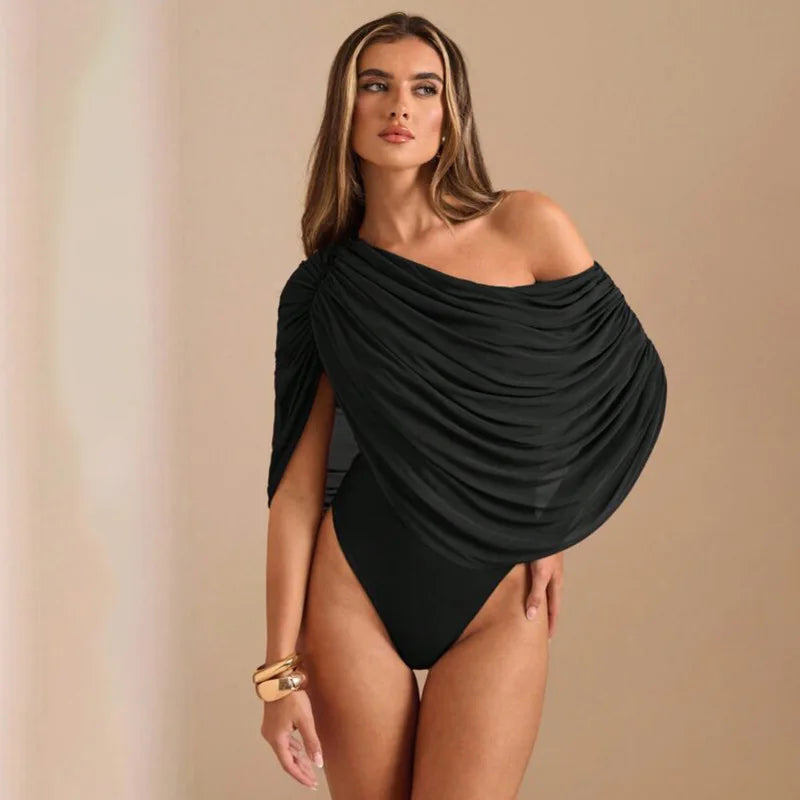 Woman wearing a black off-shoulder swimsuit against a beige background