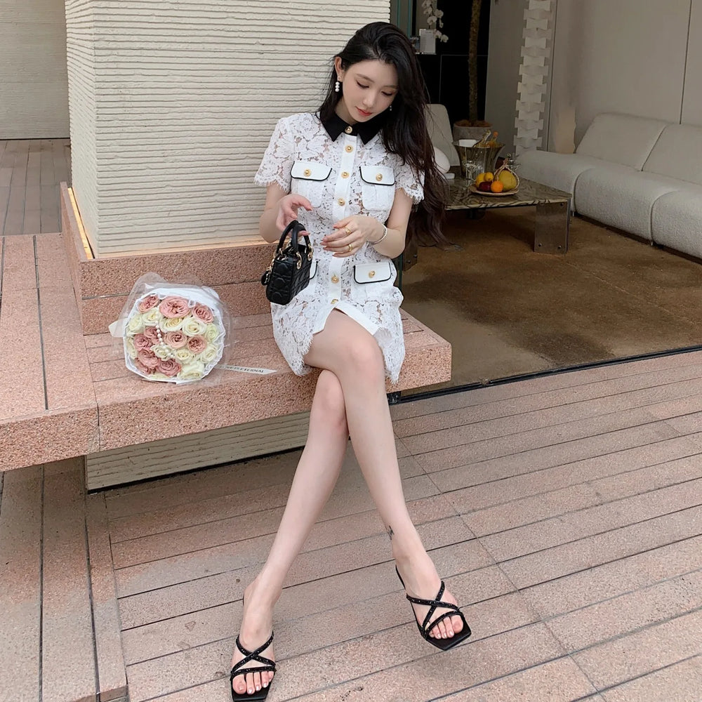 Woman in a white dress sitting on a bench with a bag and flowers.
