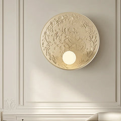 A round French wall sconce with a milk white glass lampshade, casting a soft glow in a cozy bedroom. D