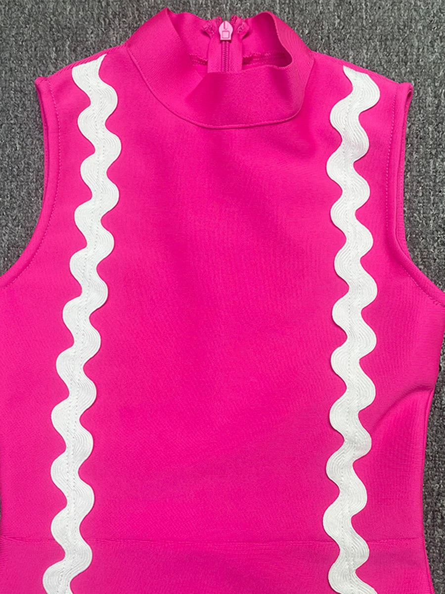 Pink sleeveless top with white ruffle details on a gray background