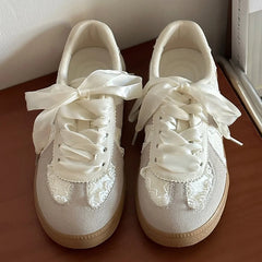 Close-up of beige lace-up ballet flats with ribbon ties