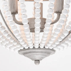 Close-up of a wooden bead pendant light, showcasing the natural texture and warm glow of the LED bulb. D