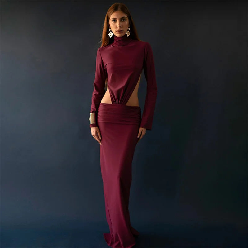 Woman wearing a burgundy dress with cut-out design against a dark background