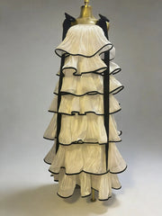 Mannequin wearing a cream-colored dress with black trim on a plain background