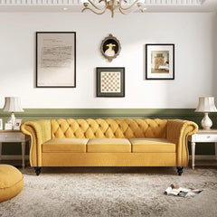 Yellow sofa in a living room with framed pictures on the wall.