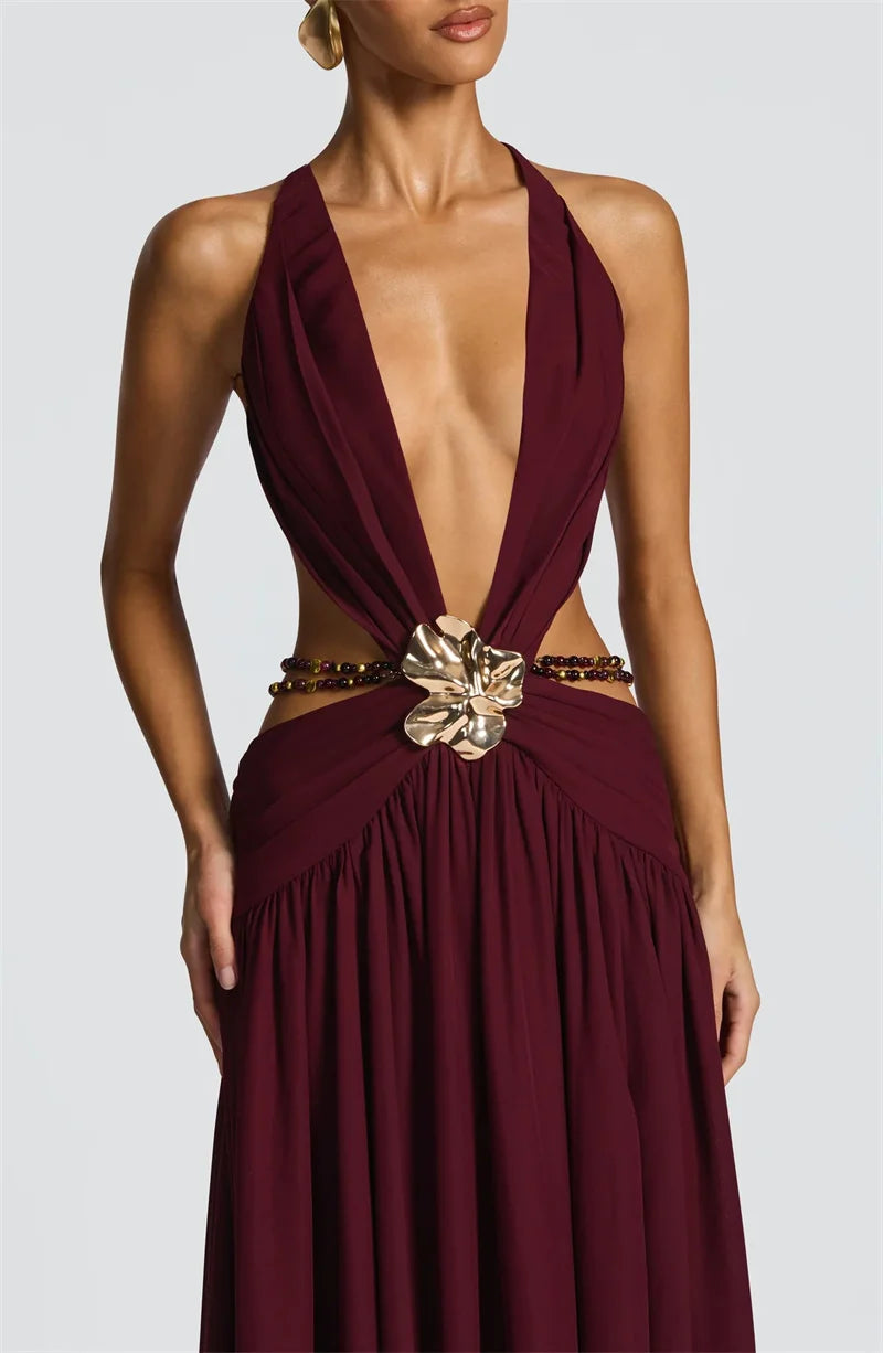 Maroon halter dress with a decorative belt on a plain background