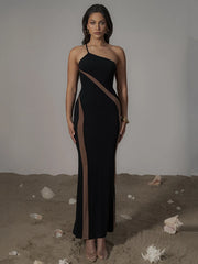 Woman wearing a black halter neck dress with sheer panels on a neutral background