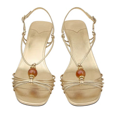 Close-up view of gold metallic slingback heels showing beaded detail.