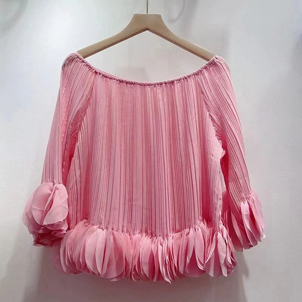 Pink pleated off-shoulder blouse on hanger