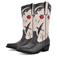 Pair of black and beige cowboy boots with floral and bird designs on a white background