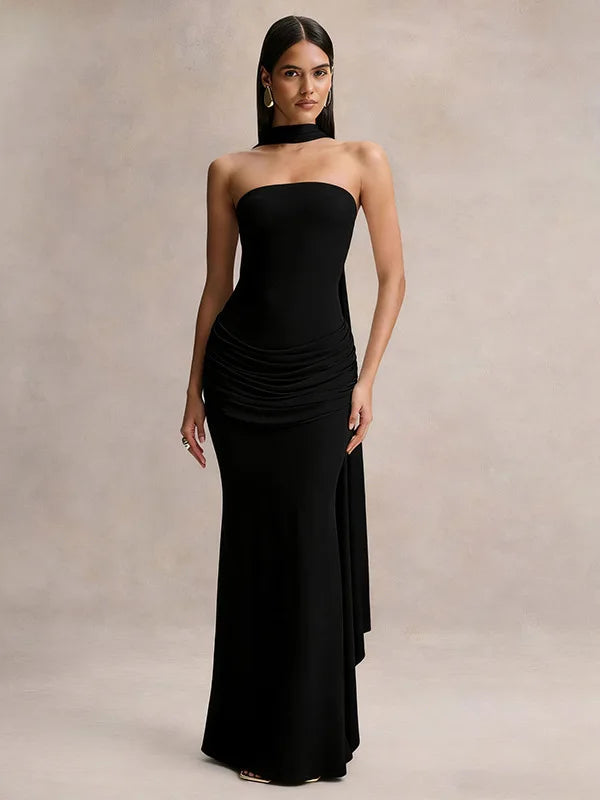 Woman wearing a black strapless gown against a neutral background