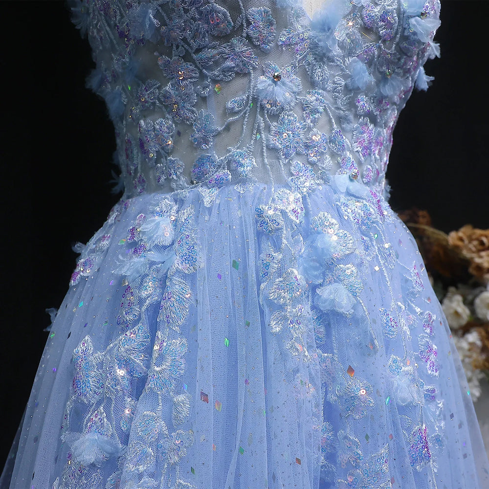 Close-up of a blue embroidered dress with floral details on a dark background