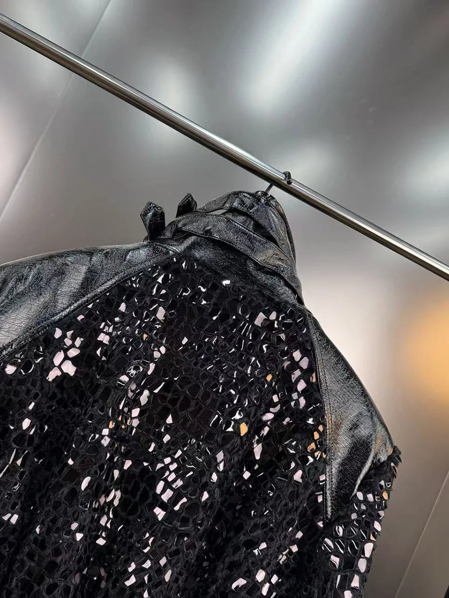 Black sequin jacket hanging on a rack against a neutral background
