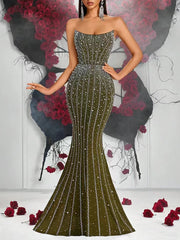 Woman wearing a sparkling green evening gown with a floral and black background