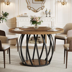 Dining room with a round wooden table and chairs, featuring a decorative mirror and floral arrangement.