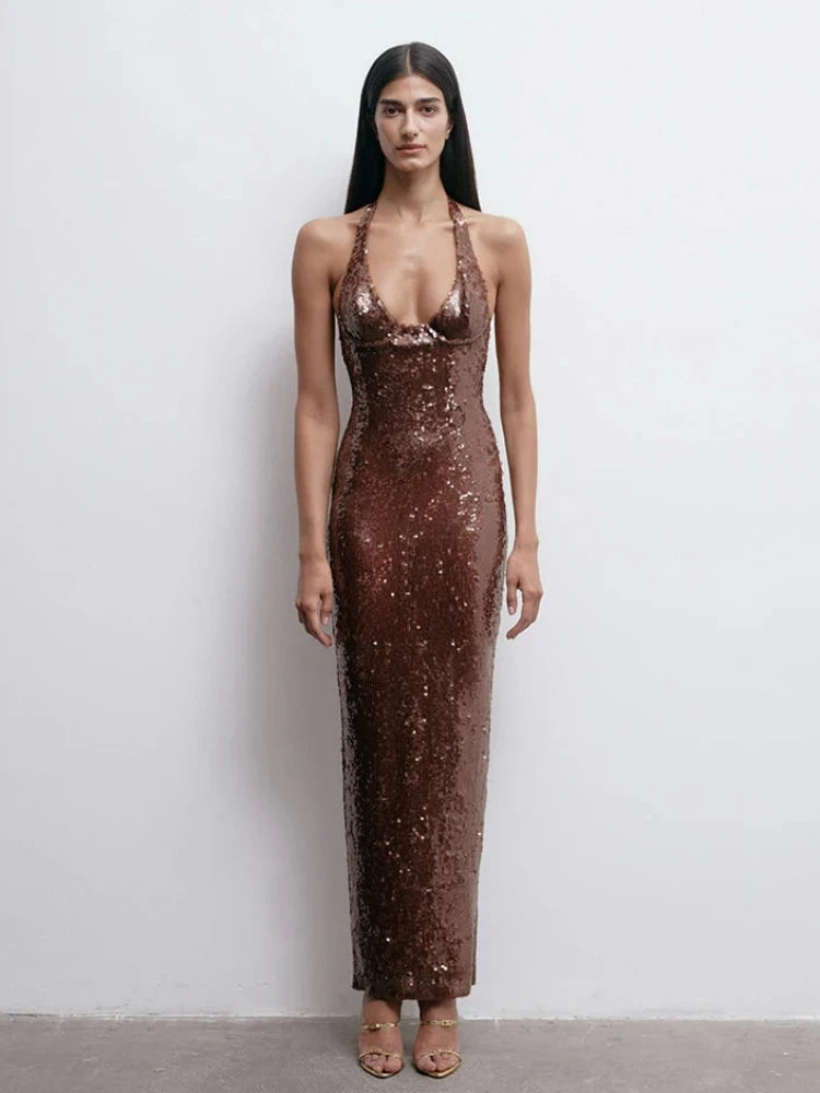 Woman wearing a long brown sequin dress against a white background