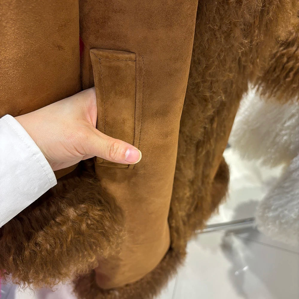 Close-up of a brown suede jacket with a hand touching the fabric