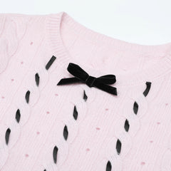 Close-up of the black velvet bow on the pink knit sweater