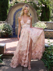 Woman in a floral dress standing outdoors with a decorative arch and plants in the background