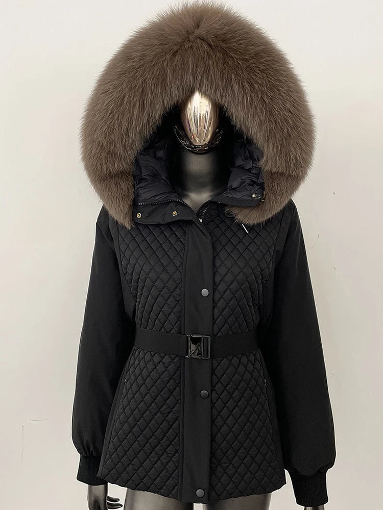 Black quilted jacket with large fur hood on a mannequin against a white background