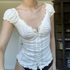 White lace top on a mannequin against a neutral background