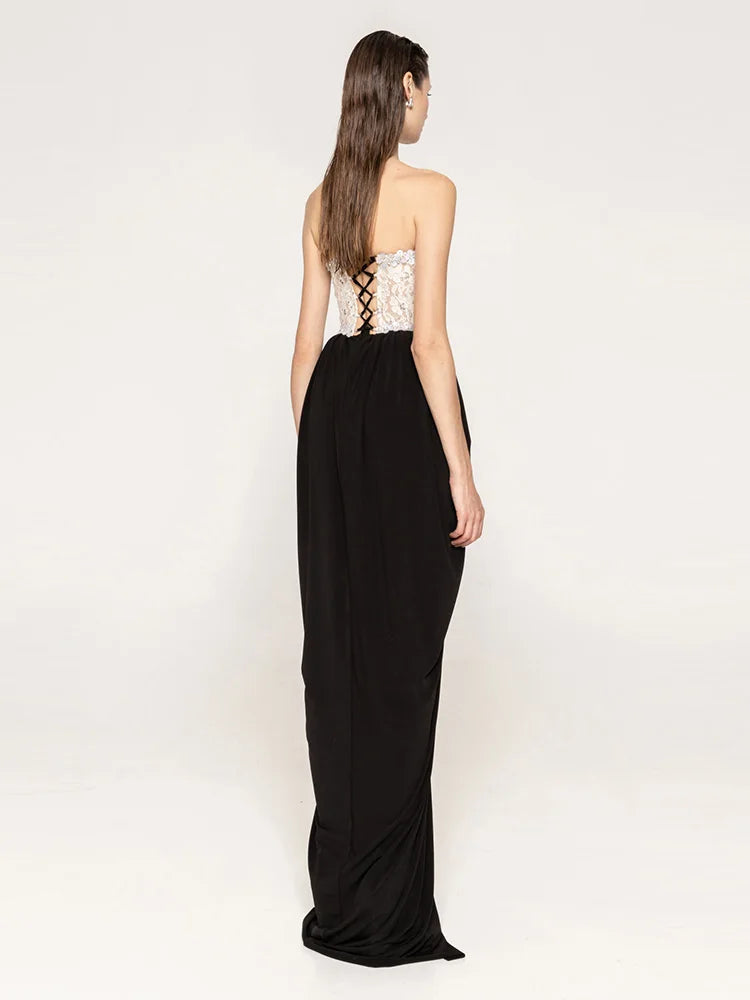 Woman wearing a black evening gown with a white lace bodice on a white background