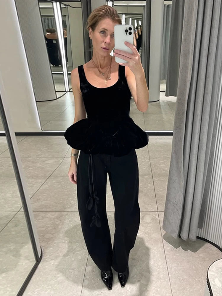 Person wearing a black outfit with a puffed top in a fitting room.