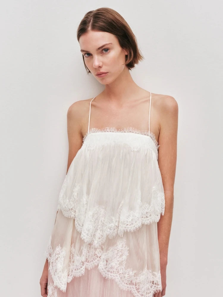 Woman wearing a white lace nightgown against a plain background