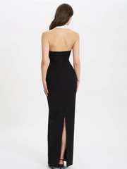 Black strapless gown with a high slit on a white background