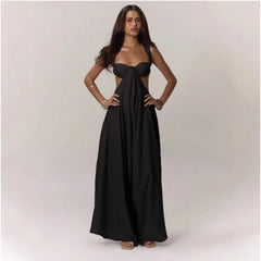 Woman wearing a black strapless jumpsuit with cut-out design on a plain background