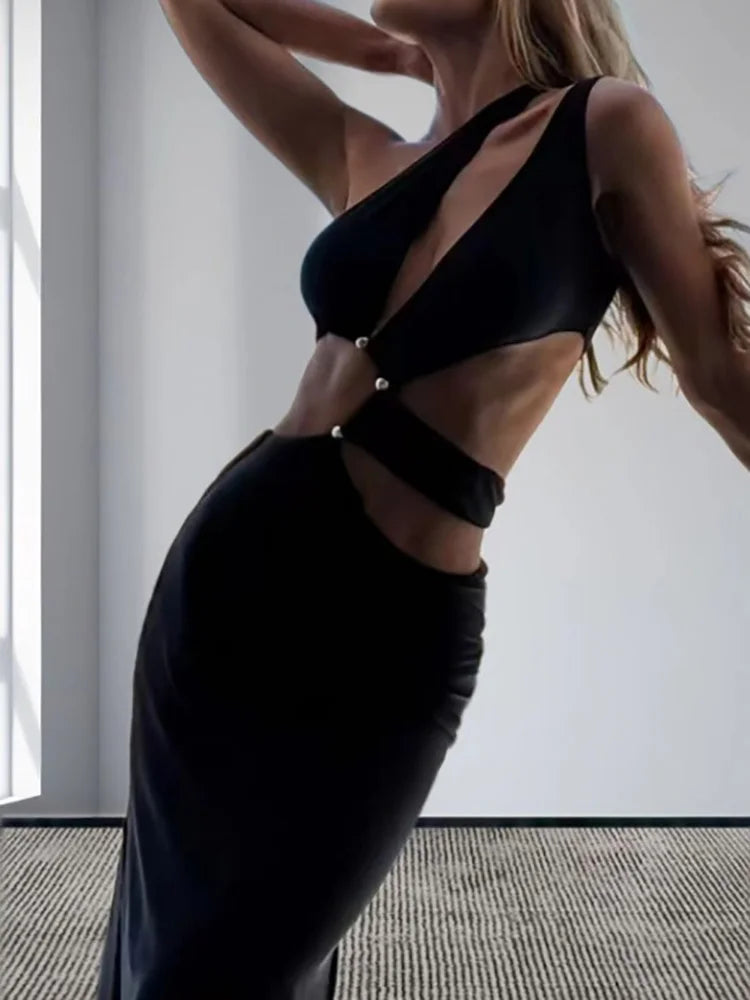 Woman wearing a black dress with cut-out design in a minimal indoor setting